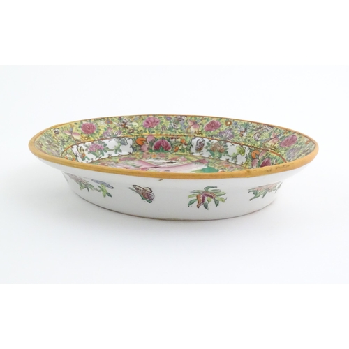 45 - A Cantonese / Chinese famille rose dish of oval form, the centre decorated with figures, bordered by... 