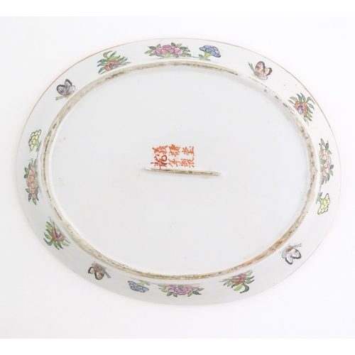 45 - A Cantonese / Chinese famille rose dish of oval form, the centre decorated with figures, bordered by... 
