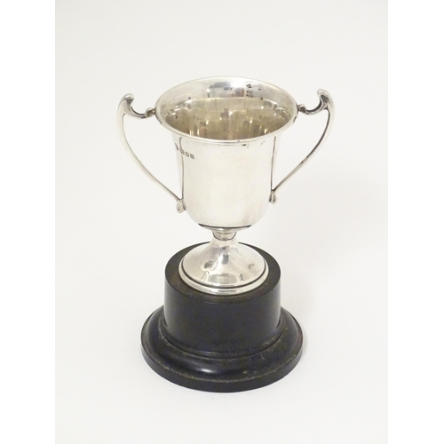 314 - An Art Deco miniature silver twin handled trophy cup with socle base, hallmarked London 1937, maker ... 