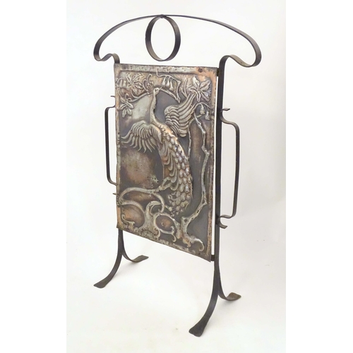2092 - An Art Nouveau cast and wrought metal firescreen, the central section decorated with depiction peaco... 