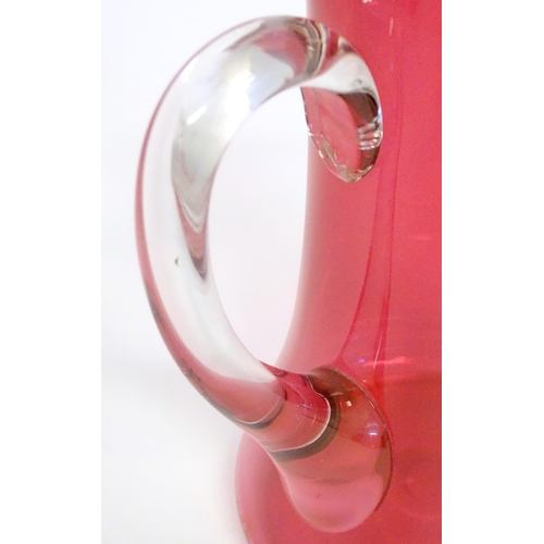 162 - A cranberry glass jug with clear glass loop handle. 10