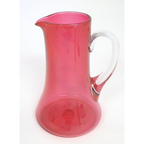 162 - A cranberry glass jug with clear glass loop handle. 10
