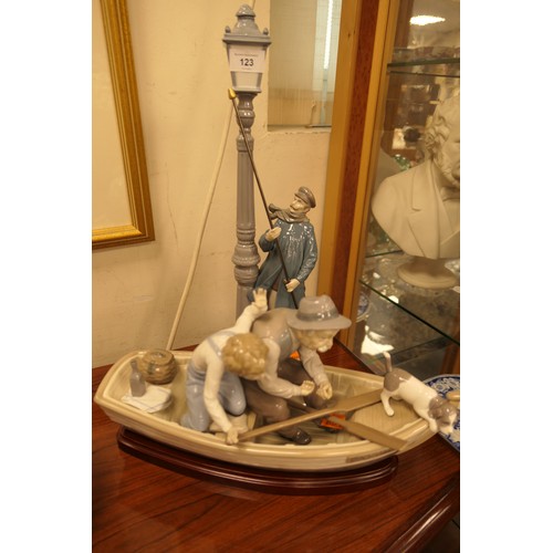 123 - Two Lladro figures, one a gentleman lamplighter, the other a grandfather and child in a fishing boat... 