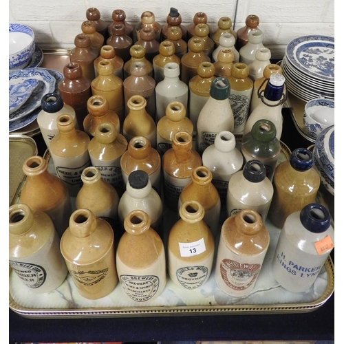 13 - Mixed named and unnamed salt glazed stoneware ginger beer and other bottles including a printed and ... 