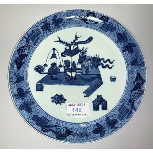 140 - A Chinese plate decorated in blue & white with antiquities on a low table, fish motifs to the rim, d... 