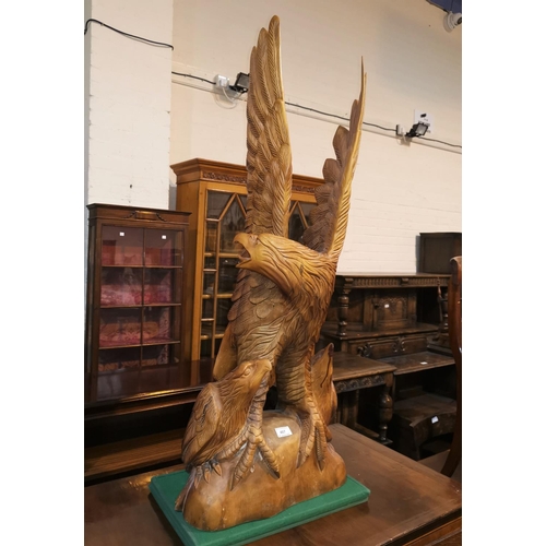 487 - A large carved wood sculpture depicting an eagle with outstretched wings, with 2 young, height 107 c... 