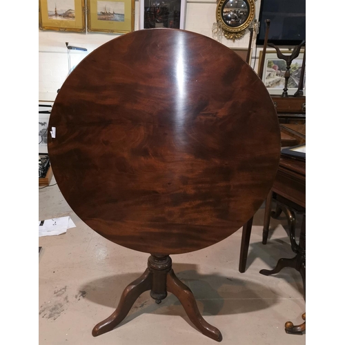 613 - A Georgian mahogany occasional table with circular tilt top, on turned baluster column and triple sp... 