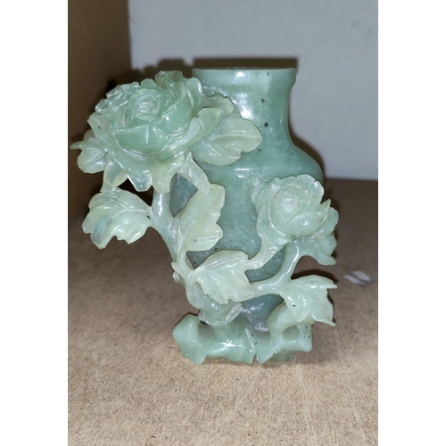 69 - A Chinese green jade vase with carved and pierced decoration of flowers, 13 cm