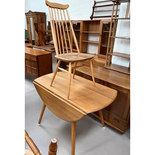 521 - An Ercol light oak dining suite comprising table with circular drop leaf top and 4 stick back chairs