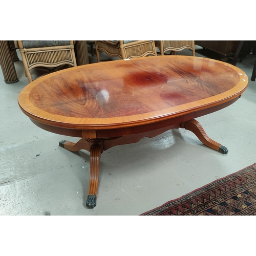 747 - A reproduction coffee table with oval top, on splay feet