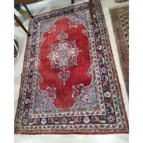 917 - A 20th century red ground hand knotted Persian rug with floral medallion and borders, 184 x 122cm