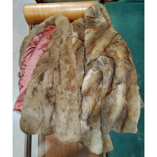 107B - A light brown, half length fur coat and another fur coat.