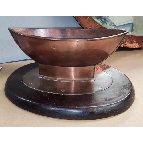 28A - An Arts & Crafts Copper Table Centre, in the form of a boat, on a wooden stand. Length 33cm.