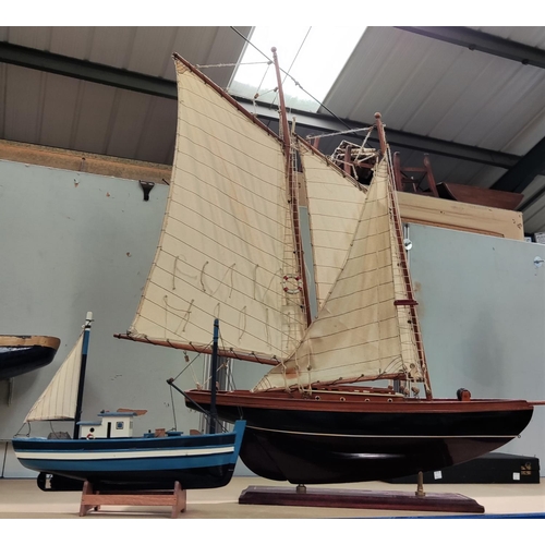 149 - Two wooden model yachts, the larger in full sail