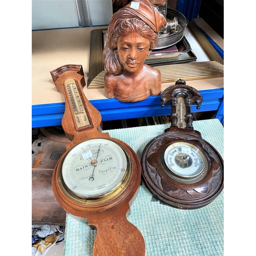 25B - A carved aneroid barometer, another carved wooden South East Asian bust