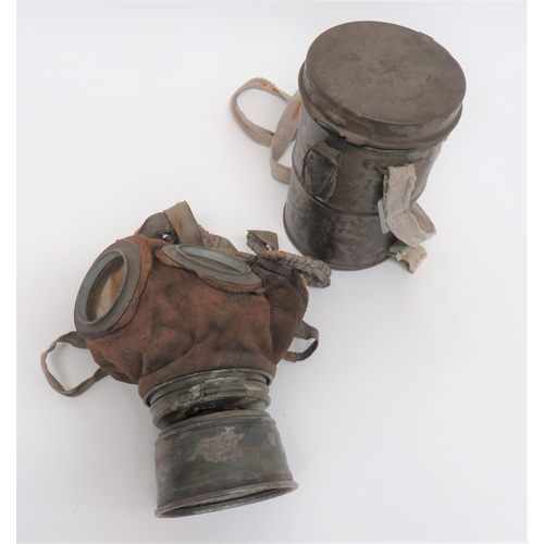 Scarce WW1 Imperial German Trench Respirator
treated leather mask with circular eye lenses.  Grey, sprung braid head harness.  Lower, removable, screw off, small filter.  Complete in its green painted, steel canister.  Still retaining its grey webbing braid shoulder strap.  Mask still in supple condition.  