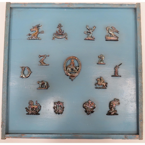 Various Silvered Livery Badges
including armoured gauntlet holding sword ... Goat's head with pierced arrow ... Monkey ... Knight's helm ... Star with pierced arrow ... Dog's head ... Mounted knight.  All mounted on a board and in a glazed frame.  15 items.