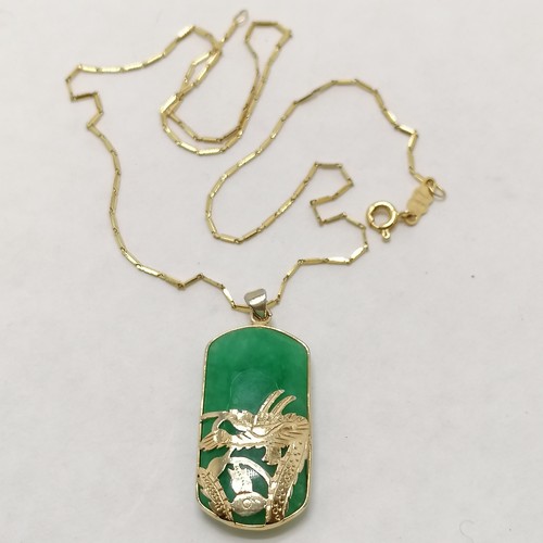 57 - 18ct marked gold 42cm chain (3g) with a jade pendant with dragon detail in a gilt metal mount