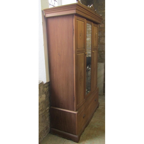 2052 - An Edwardian stripped walnut sectional wardrobe enclosed by three three-quarter length panelled door... 