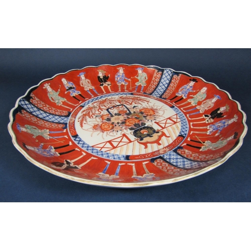 45 - A large oriental charger in the 18th century imari style with flower vase detail to the centre surro... 