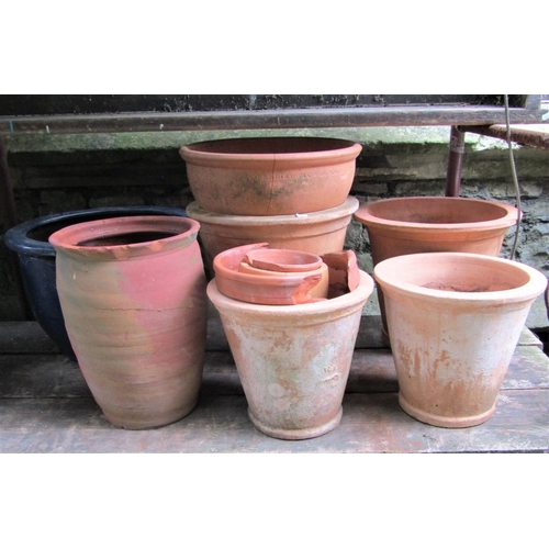 1525 - A small quantity of outsized and partially weathered terracotta flower pots of varying size and desi... 