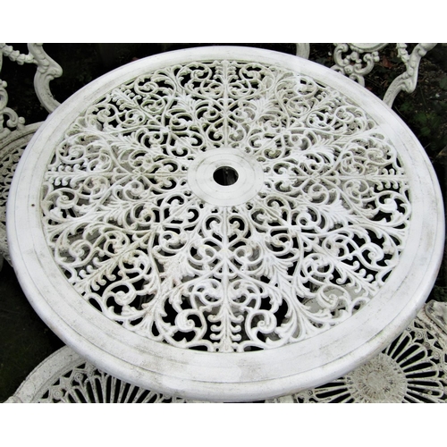 1543 - A weathered cream painted cast aluminium garden terrace table with decorative circular pierced radia... 