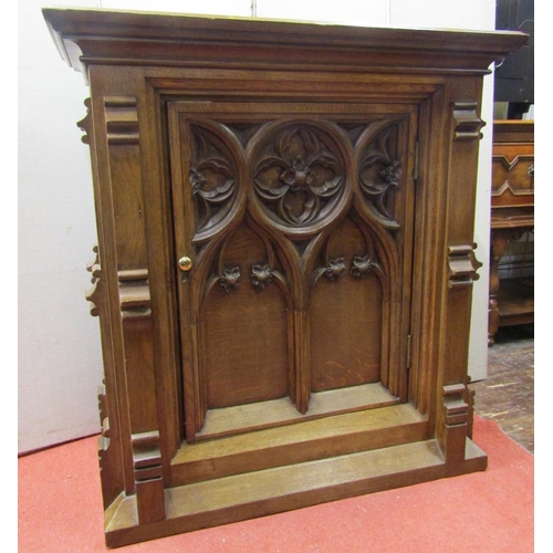 A Victorian oak cabinet with Gothic tracery detail, enclosed by a single door with further applied mouldings, 97cm high x 89cm wide