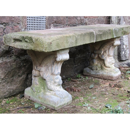 2040 - A weathered three sectional garden bench with later associated natural stone slab seat raised on a p... 