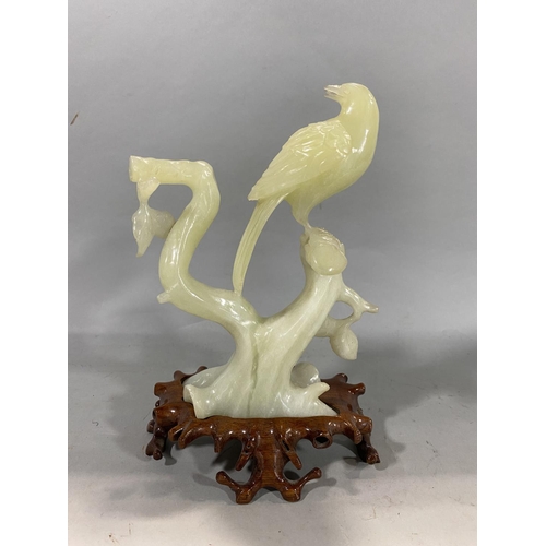 Chinese jade type carved study of a bird on a branch, 21cm high
