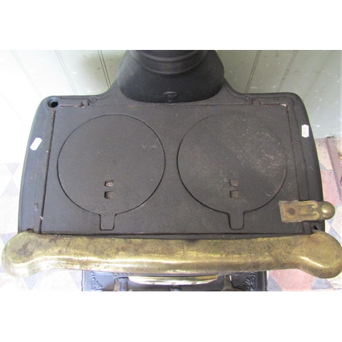2053 - A cast iron stove with foliate detail, loose brass coated fittings, pierced cover, front and side do... 