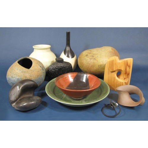 1014 - A collection of studio pottery wares including two pebble shaped vessels with rustic glaze and paint... 