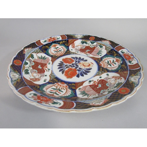 38 - A 19th century imari type charger with male character and floral decoration, with shaped rim and imp... 