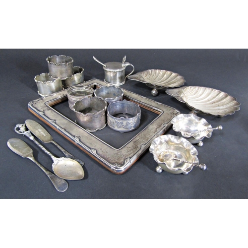 A mixed collection of silver tableware including two scallop dishes, eight napkin rings, salts and spoon, silver photo frame (collection) 10.3oz