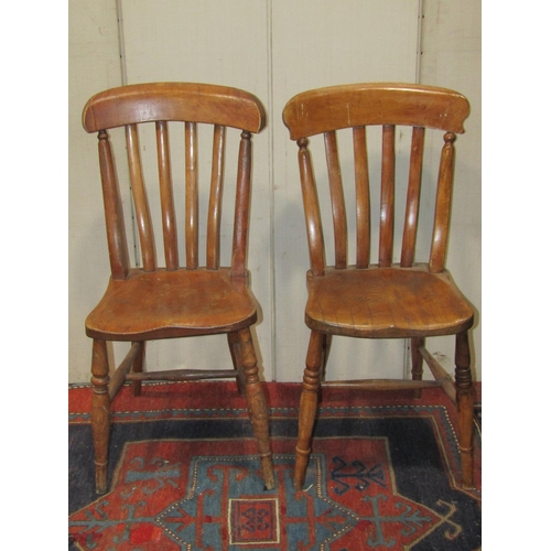 A harlequin set of eight Windsor elm and beechwood lathe back kitchen chairs raised on turned supports and stretchers
