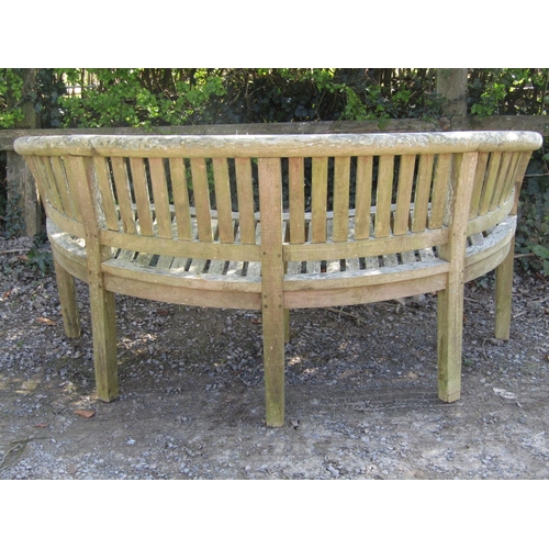 1 - A weathered teak banana shaped garden bench with slatted seat and back, 164cm long