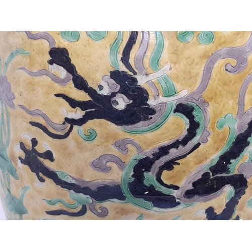 1065 - A 19th century Chinese ceramic barrel with trailing dragon, cloud and pearl detail, mounted within a... 