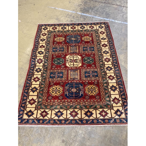 1018 - A Caucasian design red ground rug with geometric motifs within multi borders and guards, 200 x 150cm... 