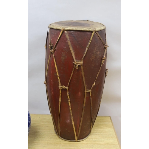 A tall tribal wooden drum, the vellum skins held by bamboo s... Barnebys