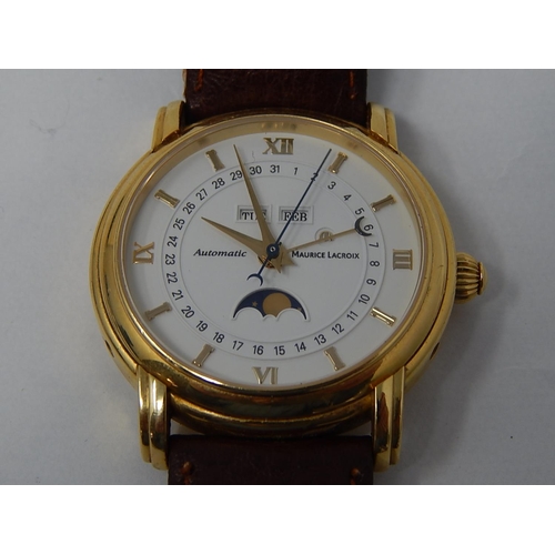 MAURICE LACROIX: 18ct Gold Gentleman's wristwatch, automatic, lever movement, caliber ETA 2824-2, blued central seconds and screws, white dial with Roman numerals and applied hour bars, central seconds, month display, weekday display, date, moon phase, sapphire glass, skeleton case back, AH 95117, diameter approx. 40 mm. Replacement leather strap & original 18ct gold buckle. Comes with Original purchase receipt 19/09/2006 £3550.00