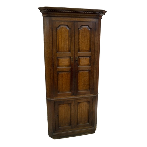 A George Iii Oak Freestanding Corner Cupboard Having Greek Key