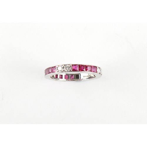 22 - A platinum ruby & diamond eternity ring, with pairs of round brilliant cut diamonds alternating with... 