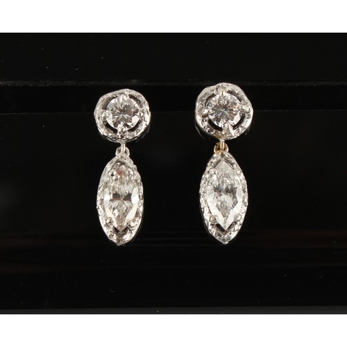 7 - A pair of unmarked white gold diamond pendant earrings, with post & butterfly fastenings, each with ... 