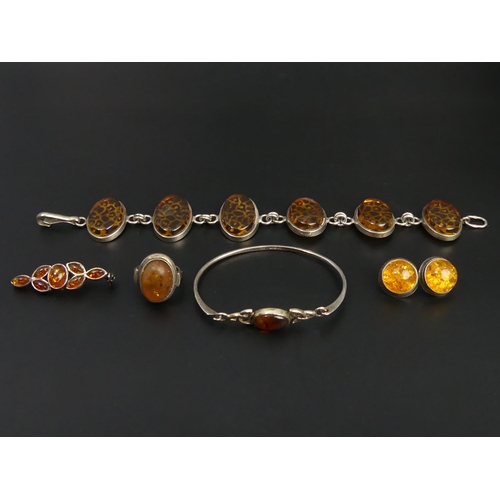 29 - Sterling silver and Amber bangle, earrings, ring, brooch and bracelet. UK Postage £12.
