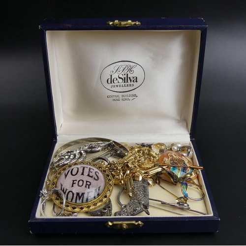 23 - A box of mixed jewellery, including silver rings, a horse brooch, suffragette brooch and a charm bra... 