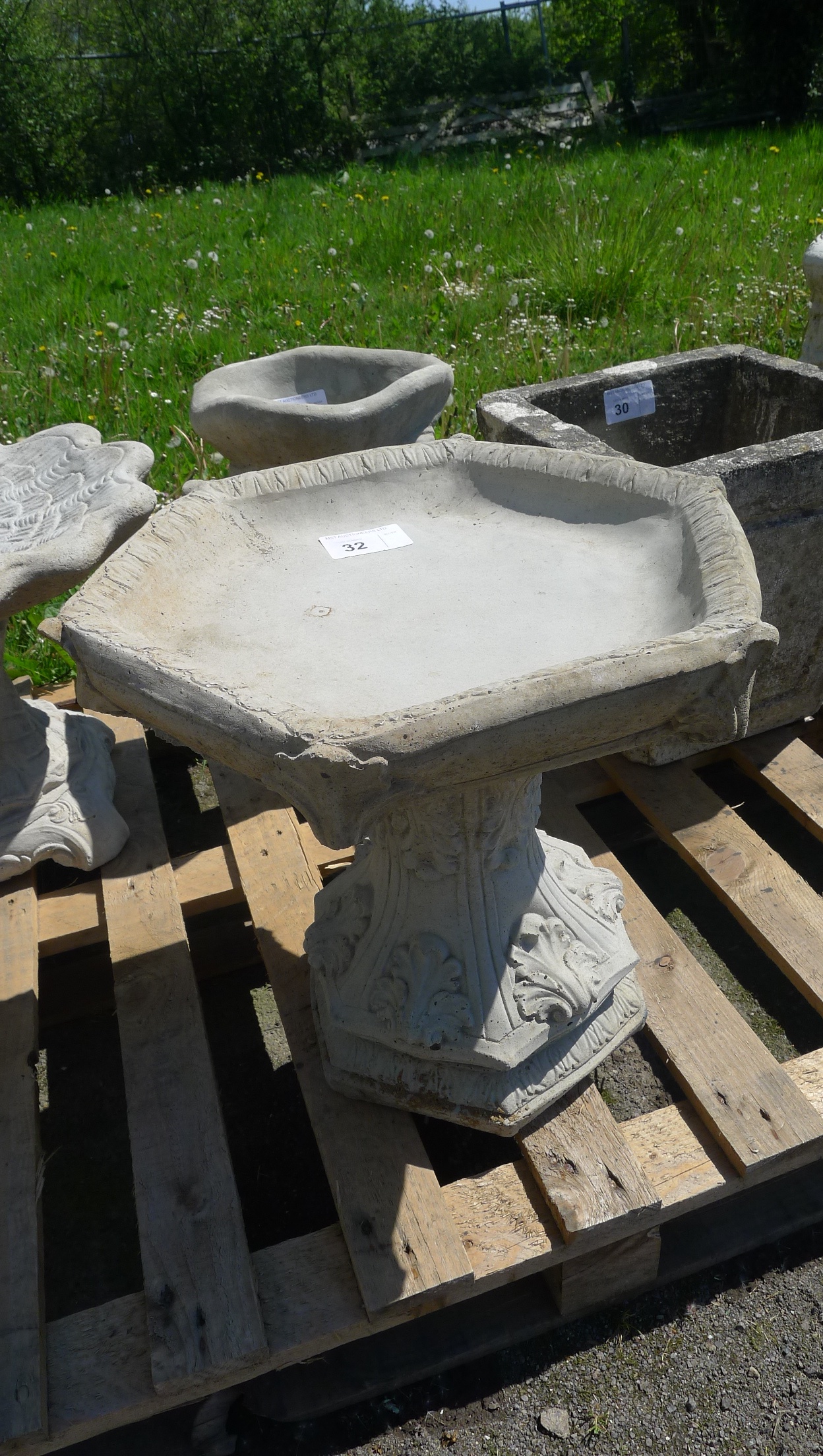 A gothic style bird bath with hexagonal top