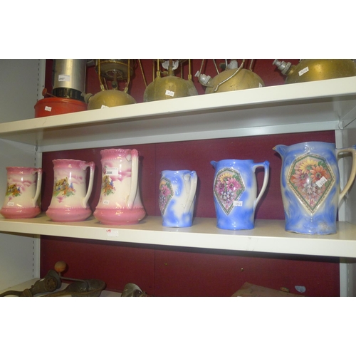 2008 - A set of pink Cottage decorated graduated jugs and a set of blue floral decorated graduated jugs