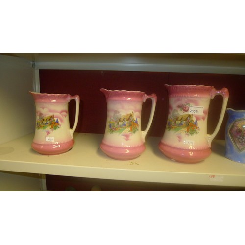 2008 - A set of pink Cottage decorated graduated jugs and a set of blue floral decorated graduated jugs
