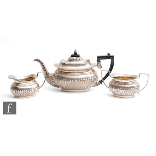 1 - A hallmarked silver boat shaped three piece tea set with part fluted decoration, presentation engrav... 