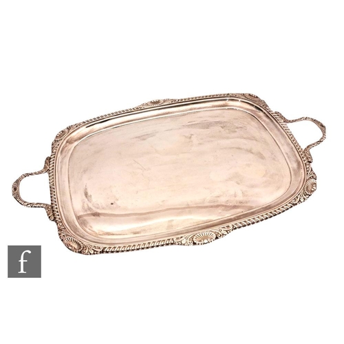 12 - An early 20th Century hallmarked silver cushioned rectangular twin handled tray of plain form with g... 