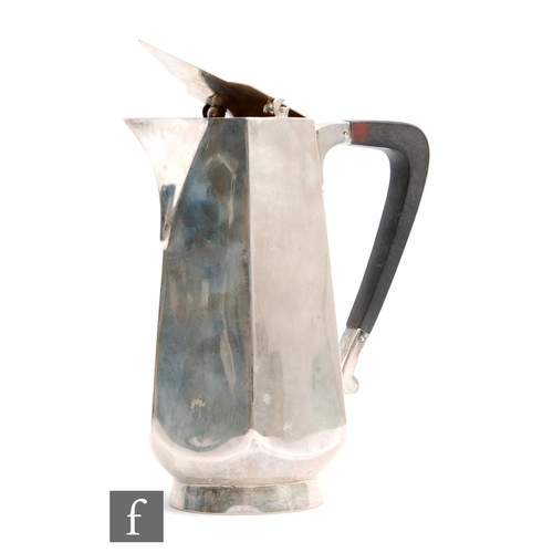 27 - A hallmarked silver milk jug of plain panelled form with flip cover and angular wooden handle, weigh... 